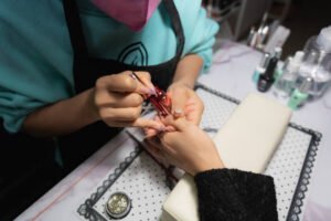 Manicurist doing manicure to client closeup